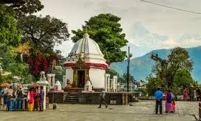 The white domed Bindhyabasini Temple shrine in Pokhara with the snow-capped Machhapuchhre peak in the distance.
