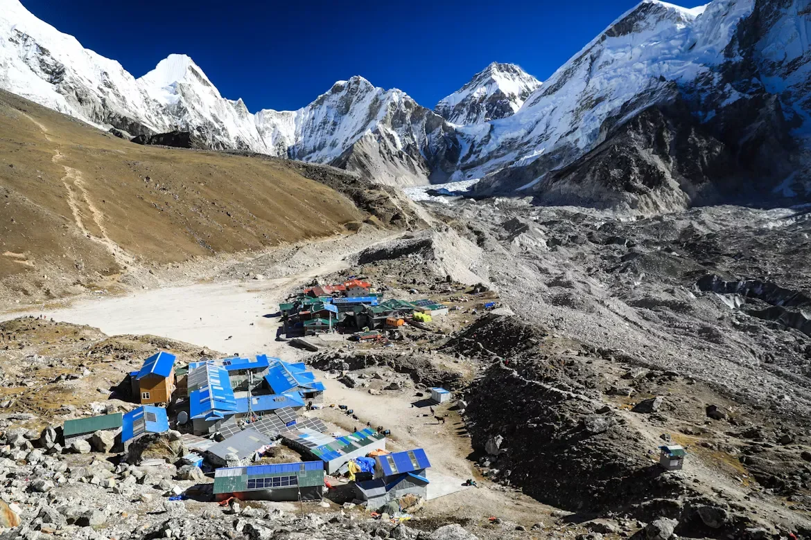 Small lodge settlement of Gorak Shep surrounded by massive sandy basins and snow-covered Himalayan peaks in the Everest region.
