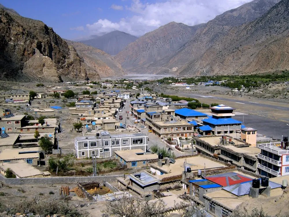High-angle panoramic view of the stone buildings with flat roofs in Jomsom Bazar, Annapurna region.