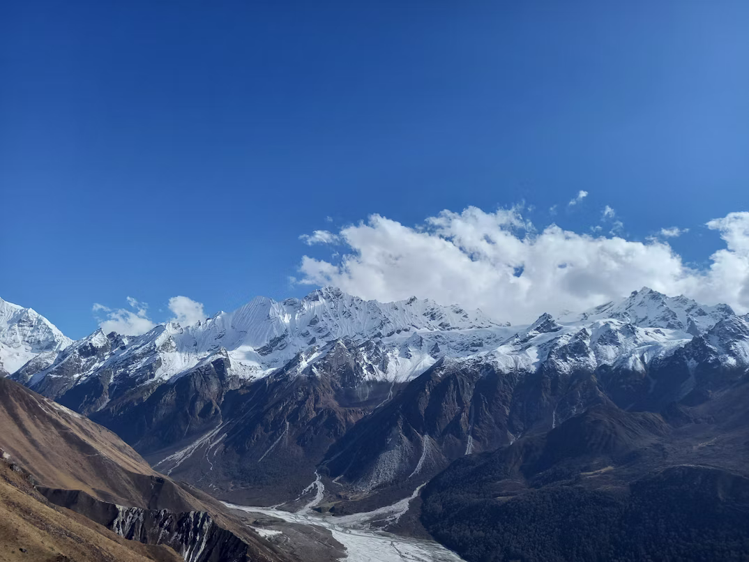 Panoramic landscape view of an open alpine valley and stone settlements in Langtang, Nepal.
