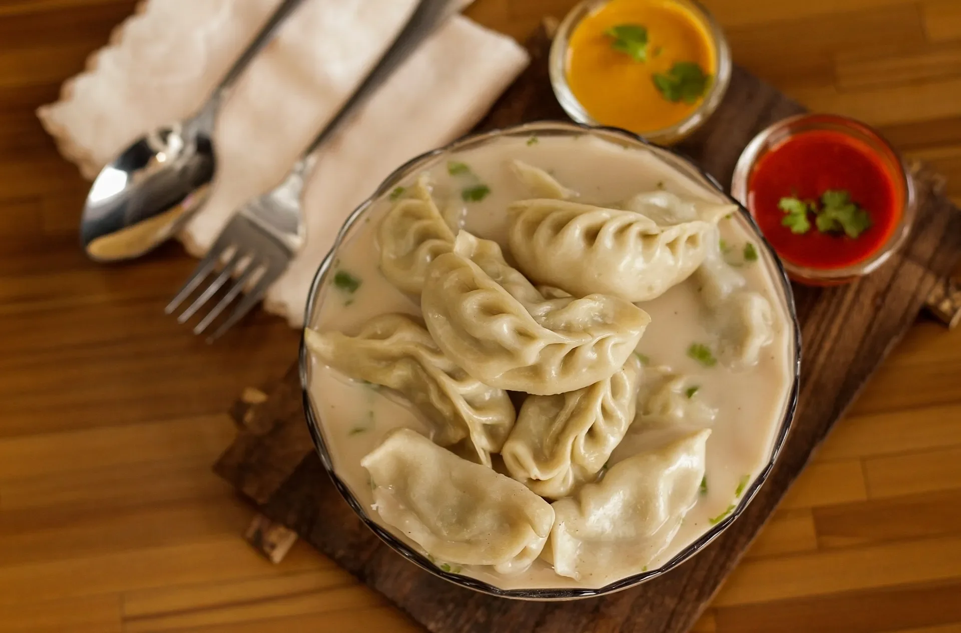 Nepalese Jhol Momo served in savory broth with vibrant sauces.
