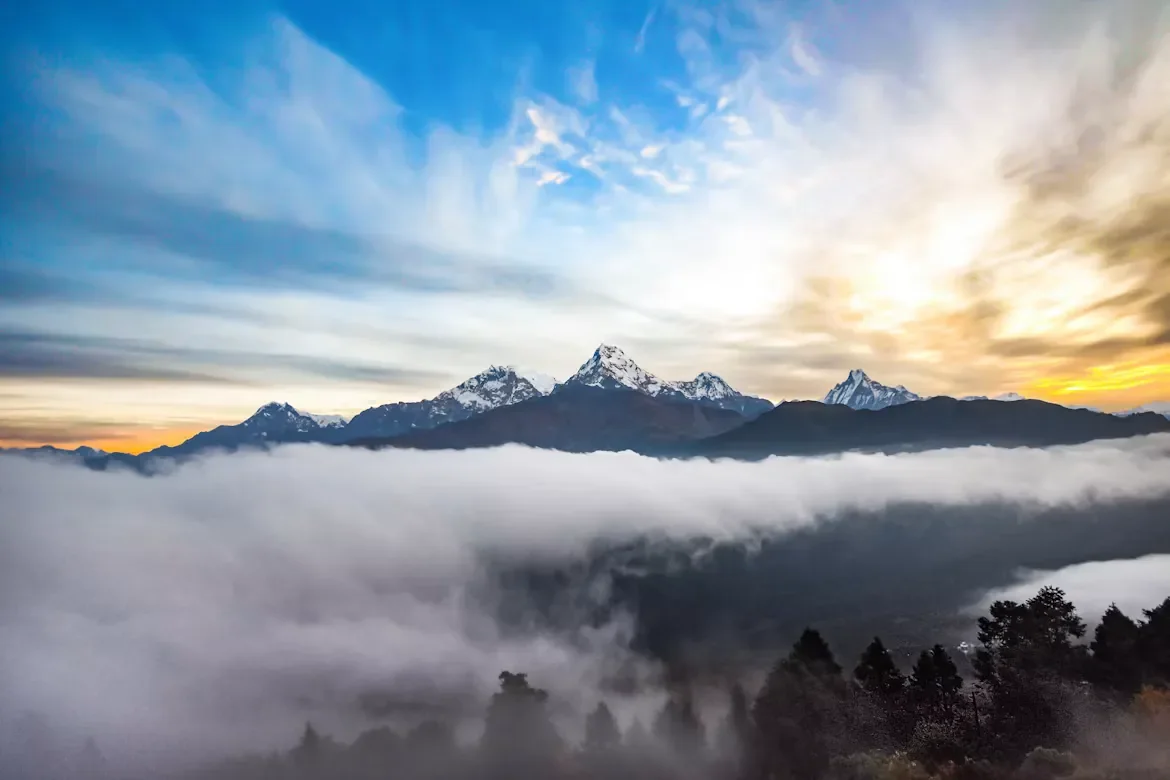 Panoramic golden sunrise over the snow-covered Annapurna mountain range above a thick sea of clouds at Poon Hill viewpoint
