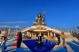 Giant sitting Lord Shiva statue at the Pumdikot temple viewpoint under a clear blue sky in Pokhara.