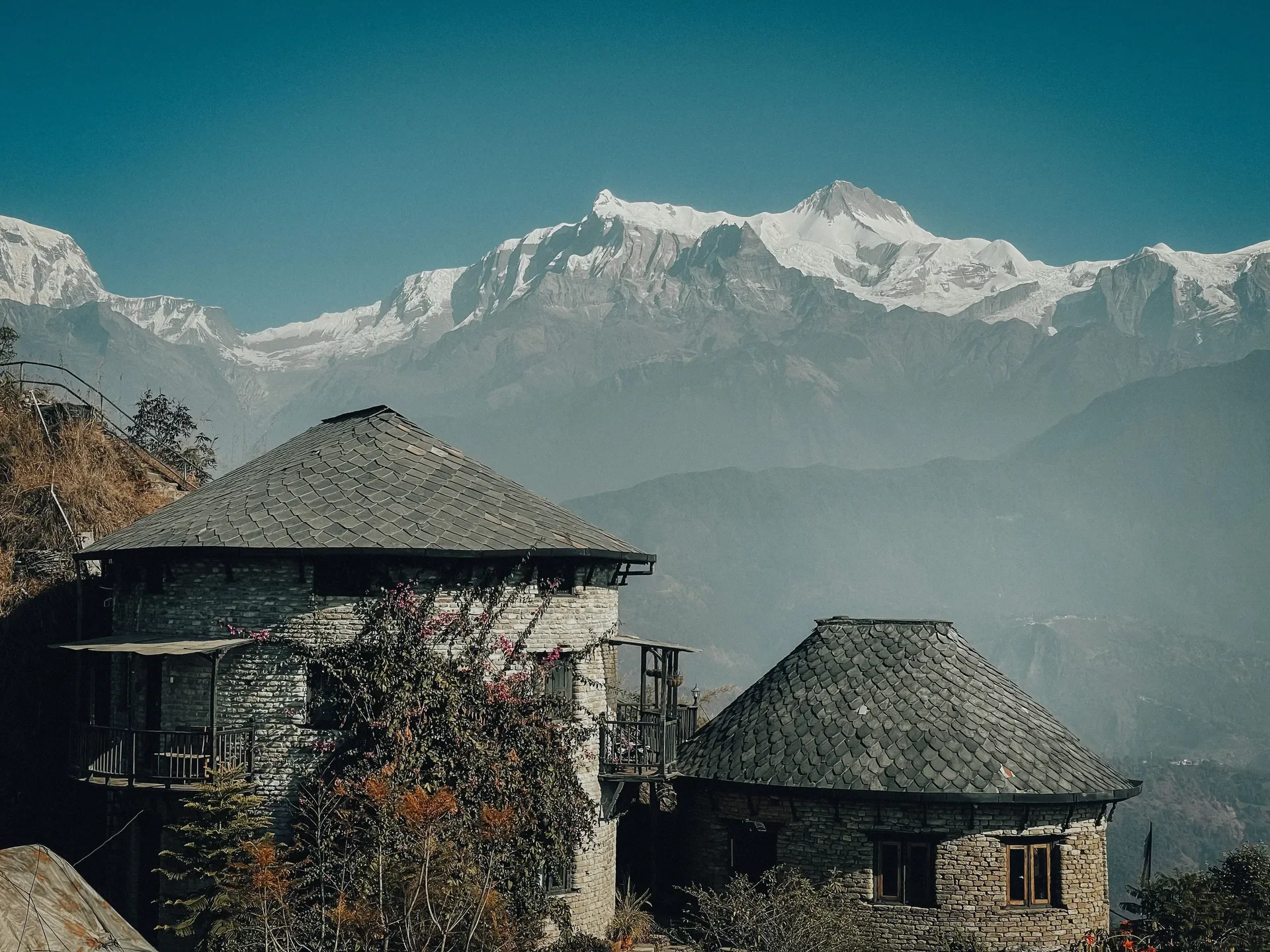  Traditional stone cottages with slate-tiled roofs at Sarangkot viewpoint overlooking the snowy peaks of the Annapurna mountain range.